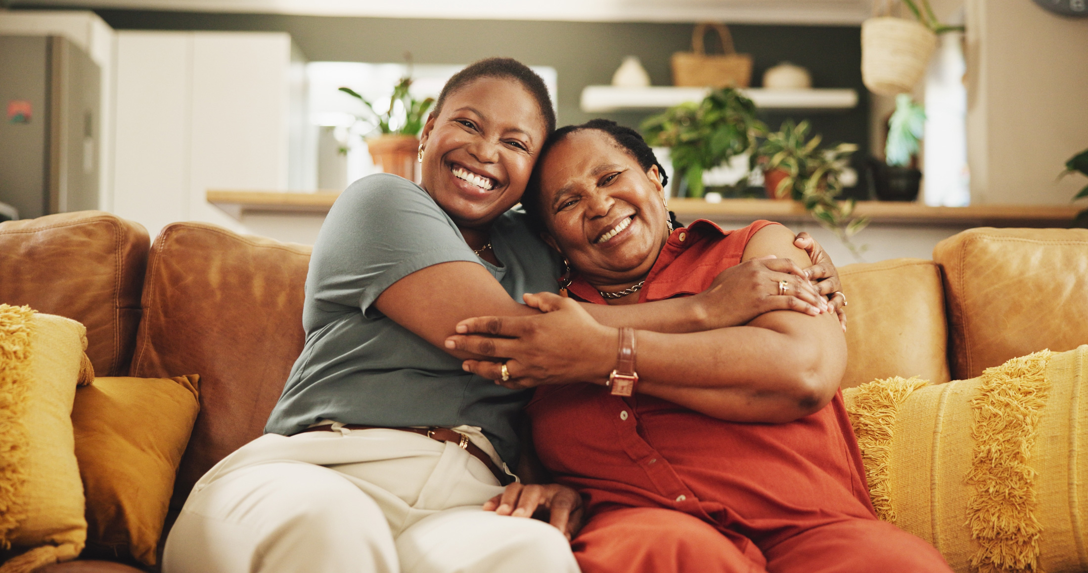 Young woman and older woman seated on couch embraced